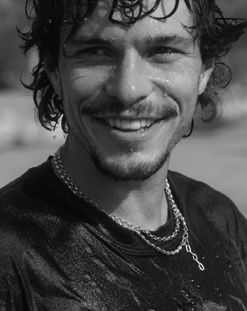 Black and white close-up of a person with a necklace and earrings.